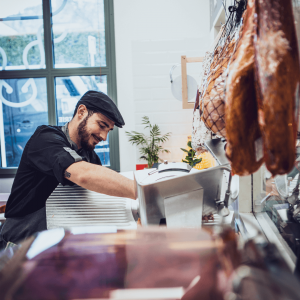 Boucher de la Boucherie des Grèses découpant du jambon